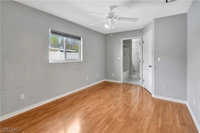 unfurnished bedroom with ceiling fan, light wood finished floors, and baseboards