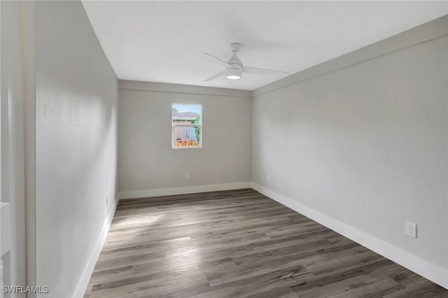 unfurnished room with ceiling fan, wood finished floors, and baseboards