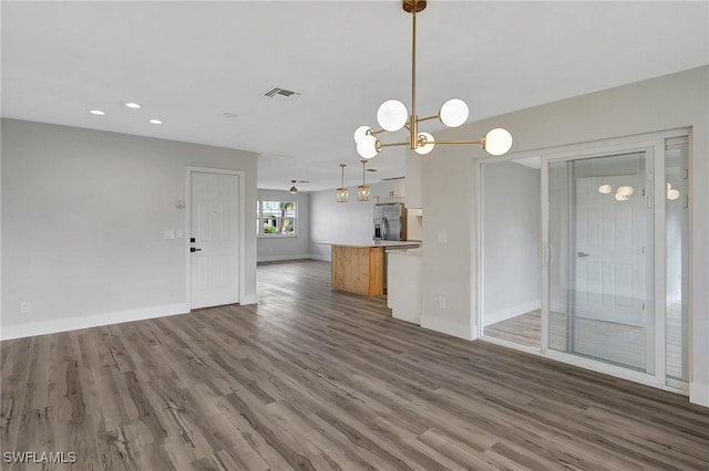 unfurnished living room featuring recessed lighting, dark wood finished floors, visible vents, and baseboards