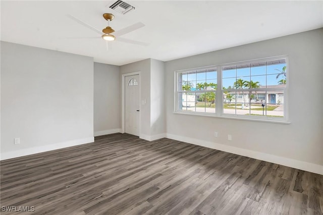 spare room featuring visible vents, dark wood finished floors, and baseboards