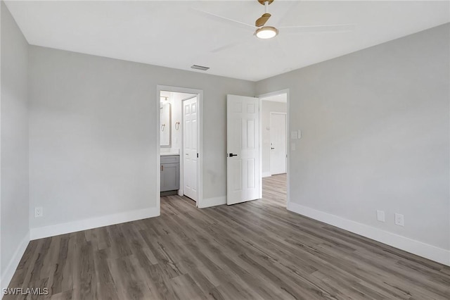 unfurnished bedroom featuring dark wood finished floors, visible vents, a ceiling fan, connected bathroom, and baseboards