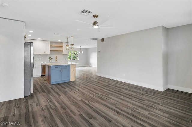 kitchen with open shelves, stainless steel appliances, light countertops, white cabinetry, and a kitchen island