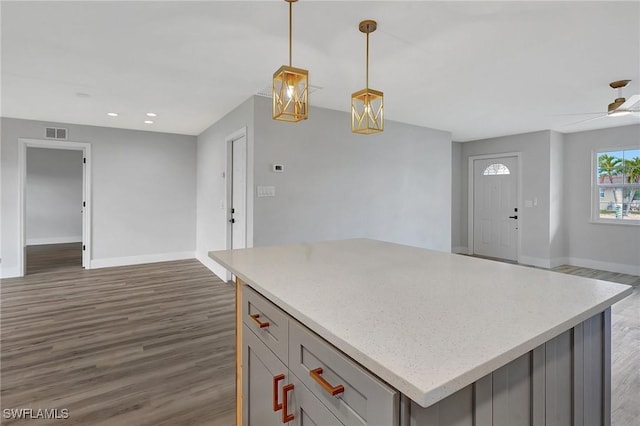 kitchen featuring dark wood-style flooring, light countertops, hanging light fixtures, visible vents, and gray cabinetry