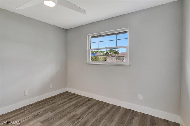 spare room featuring a ceiling fan, baseboards, and wood finished floors