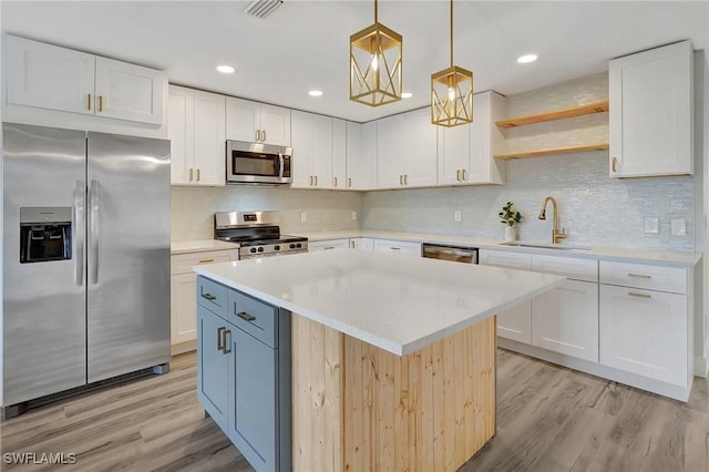 kitchen with stainless steel appliances, light countertops, white cabinetry, and open shelves