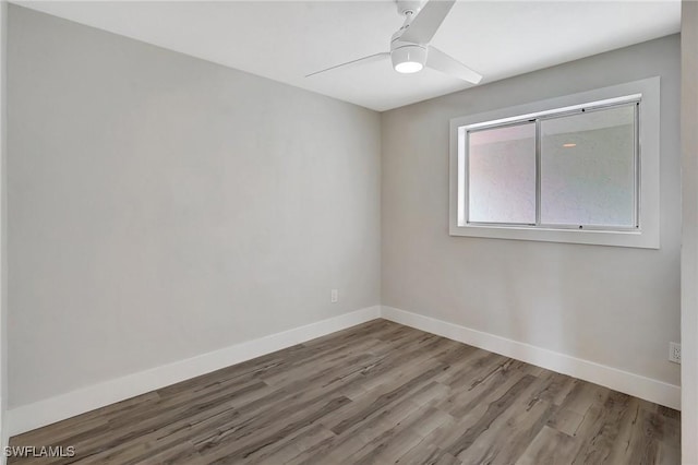 unfurnished room featuring wood finished floors, a ceiling fan, and baseboards