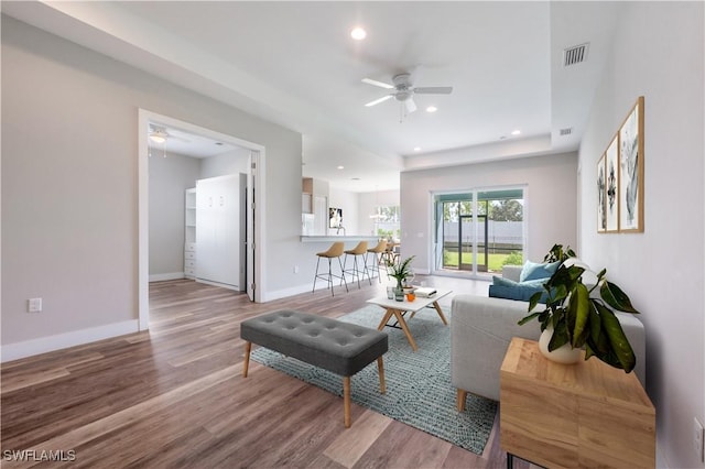 living room with baseboards, wood finished floors, and recessed lighting