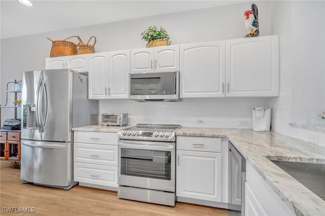 kitchen featuring white cabinetry, appliances with stainless steel finishes, and tasteful backsplash