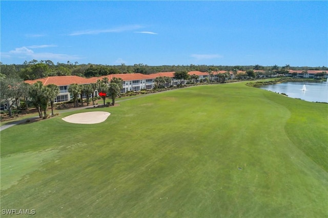 exterior space featuring a water view, golf course view, and a lawn