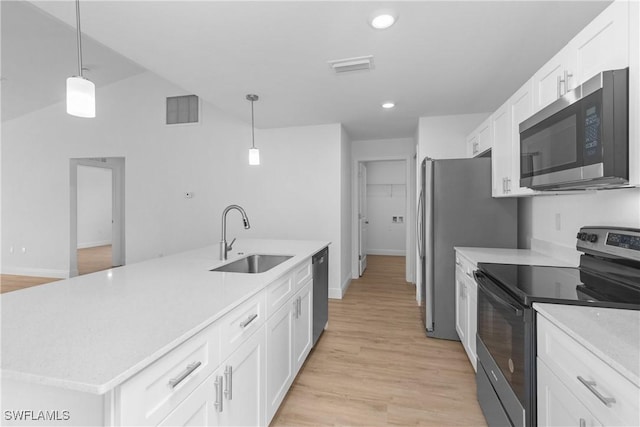 kitchen featuring a sink, white cabinets, appliances with stainless steel finishes, an island with sink, and pendant lighting