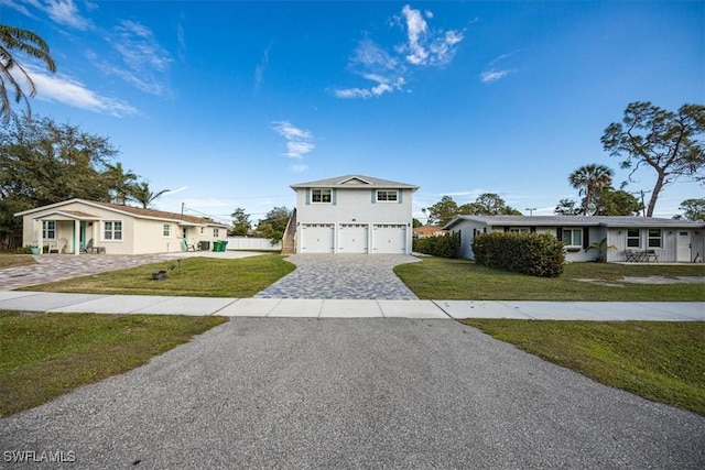 view of front of house featuring a front lawn, decorative driveway, and an attached garage