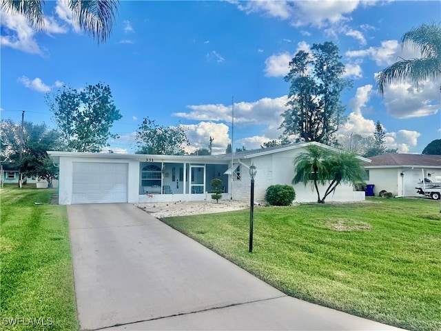 single story home featuring a garage, a front yard, and stucco siding