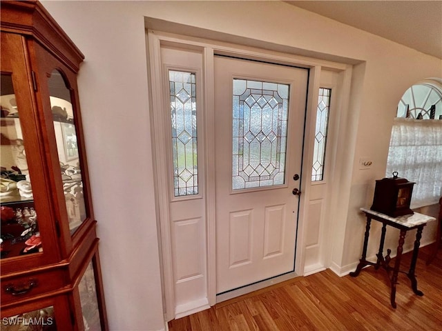 foyer entrance with baseboards and light wood-style floors