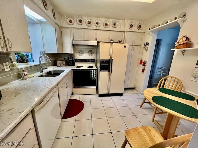 kitchen featuring light tile patterned flooring, under cabinet range hood, white appliances, a sink, and open shelves