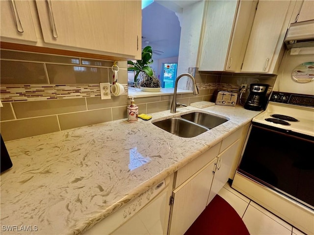 kitchen with tasteful backsplash, electric stove, light countertops, light brown cabinets, and a sink