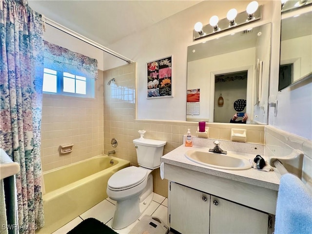 bathroom with bathing tub / shower combination, tile walls, toilet, vanity, and tile patterned floors