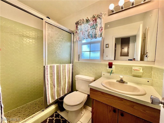 bathroom featuring a stall shower, tile walls, vanity, and toilet