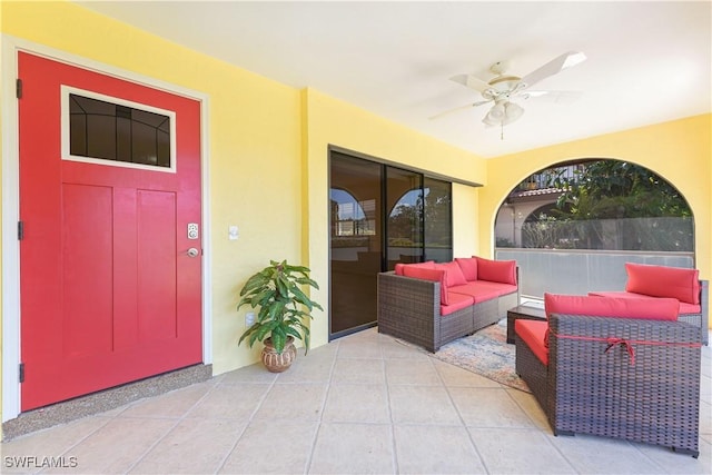 entrance to property with a ceiling fan, a patio area, an outdoor living space, and stucco siding