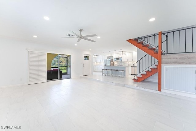 unfurnished living room featuring visible vents, stairway, a ceiling fan, and recessed lighting