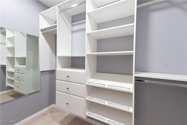 walk in closet with light tile patterned floors