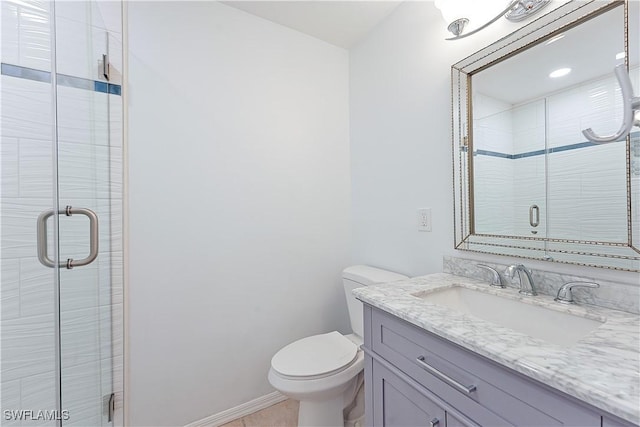 bathroom featuring toilet, a shower stall, baseboards, and vanity