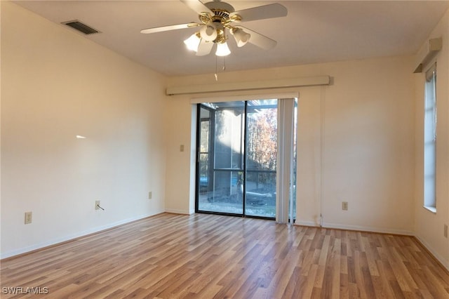 spare room featuring light wood-type flooring, baseboards, visible vents, and a ceiling fan