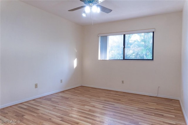 spare room featuring light wood-type flooring, ceiling fan, and baseboards