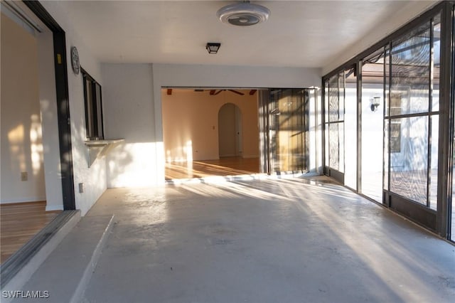 interior space featuring arched walkways and concrete flooring