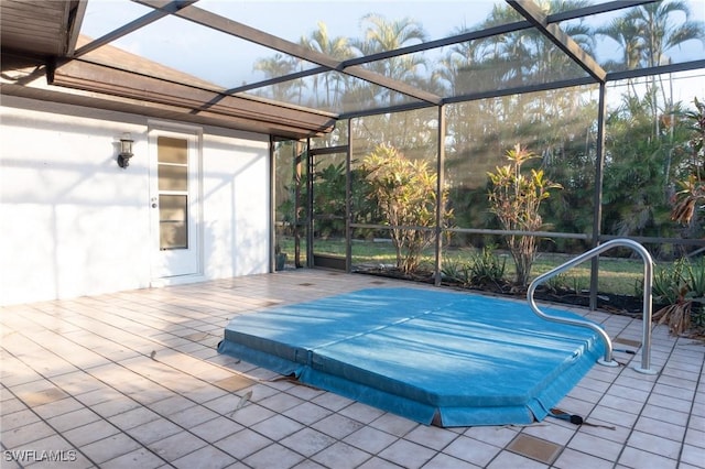 view of swimming pool featuring glass enclosure and a patio