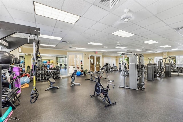 exercise room featuring a paneled ceiling, visible vents, and french doors