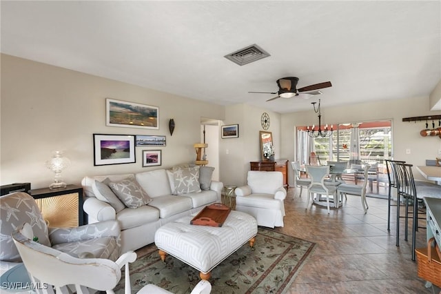 tiled living area with ceiling fan with notable chandelier and visible vents