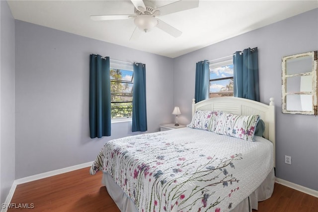 bedroom with ceiling fan, wood finished floors, and baseboards