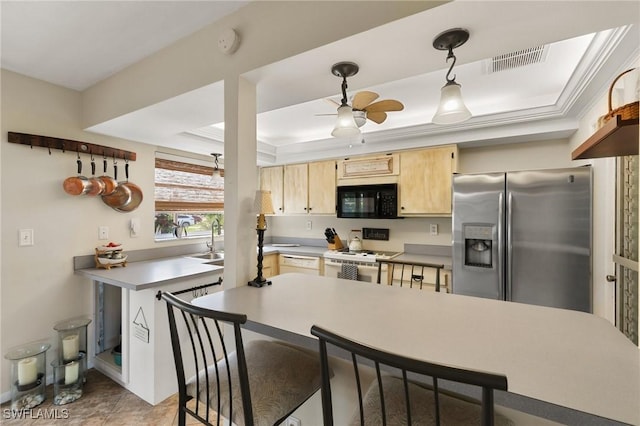 kitchen featuring visible vents, a raised ceiling, stove, black microwave, and stainless steel refrigerator with ice dispenser