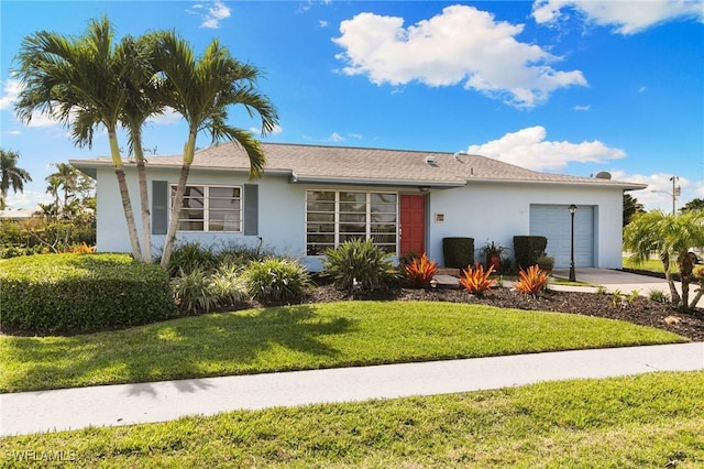 single story home with a garage, a front yard, and stucco siding