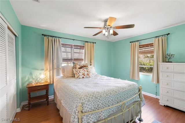 bedroom featuring a closet, wood finished floors, a ceiling fan, and baseboards