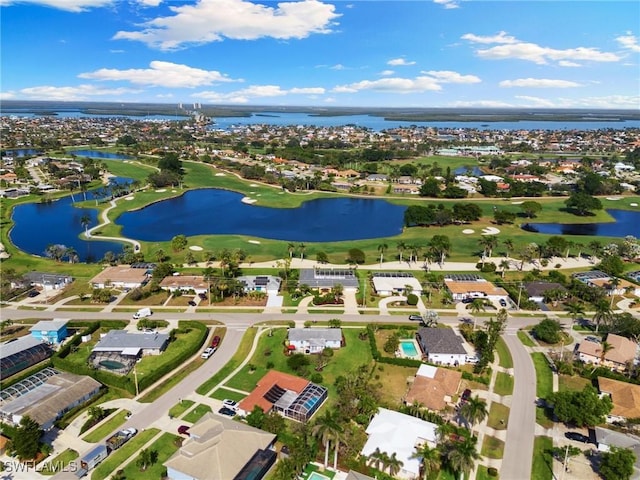 drone / aerial view with golf course view and a water view