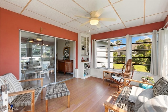 sunroom with a drop ceiling and a ceiling fan