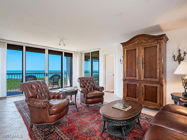 living room with light tile patterned floors, a wall of windows, and a water view