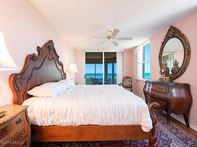 bedroom featuring access to exterior, a ceiling fan, and wood finished floors