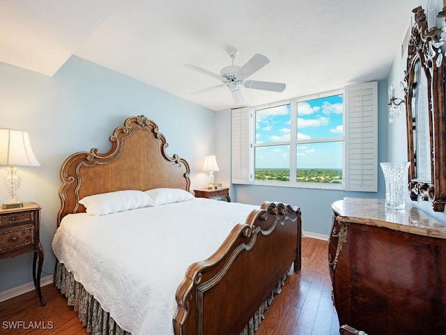 bedroom with wood finished floors, a ceiling fan, and baseboards