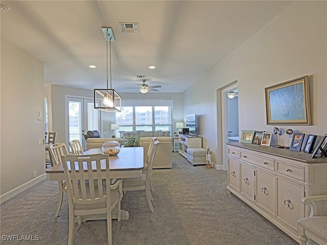 dining area featuring light colored carpet, visible vents, and baseboards