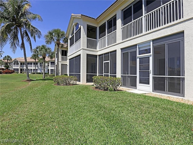 exterior space with stucco siding and a yard