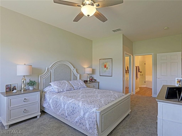 bedroom featuring light carpet, ensuite bath, visible vents, and ceiling fan