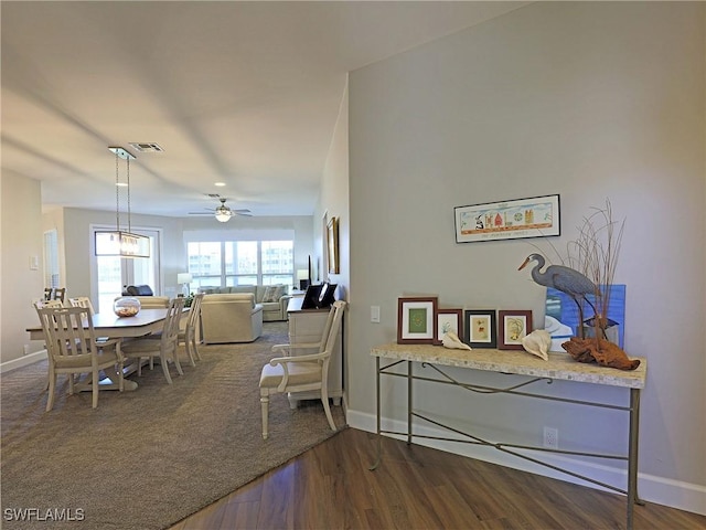 dining space with baseboards, visible vents, ceiling fan, and wood finished floors