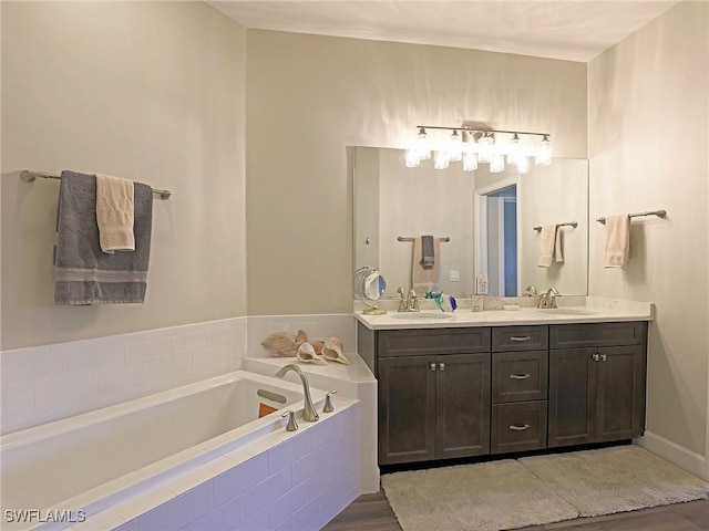 full bathroom with double vanity, a sink, and a bath