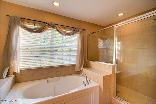 bathroom featuring a bath, recessed lighting, and a shower stall