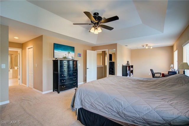 bedroom featuring a tray ceiling, baseboards, light colored carpet, and a ceiling fan