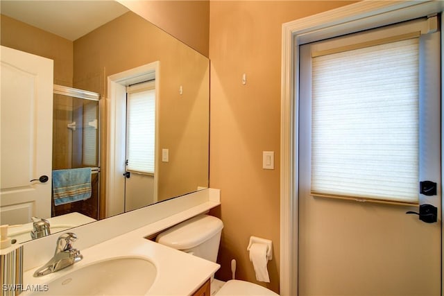 full bath featuring vanity, toilet, and an enclosed shower