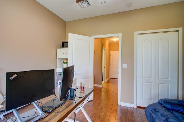 office space with visible vents, baseboards, and wood-type flooring