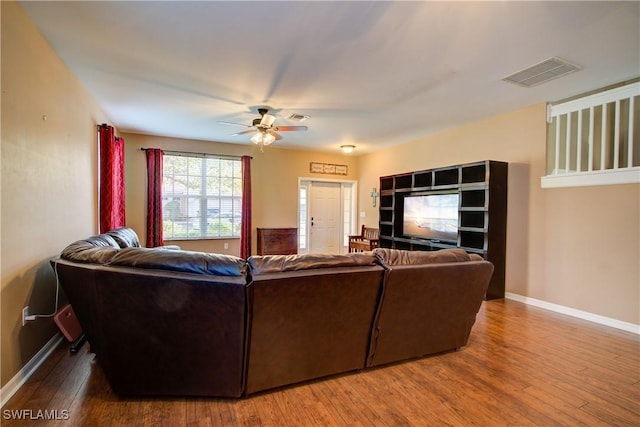 living room featuring visible vents, baseboards, and wood finished floors